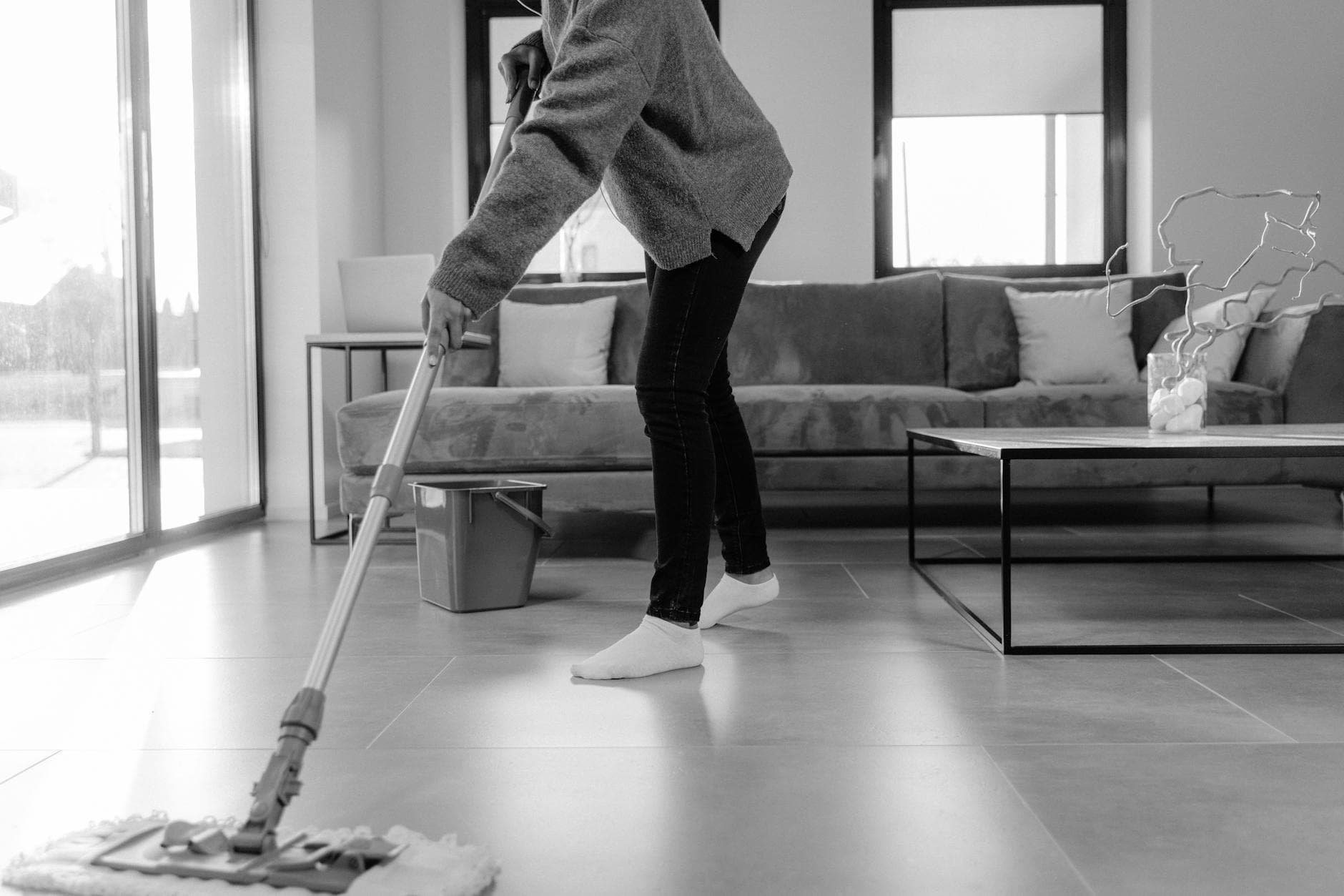 Professional NYC cleaner mopping the floor in a modern apartment living room — cleaning services in Red Hook, Brooklyn