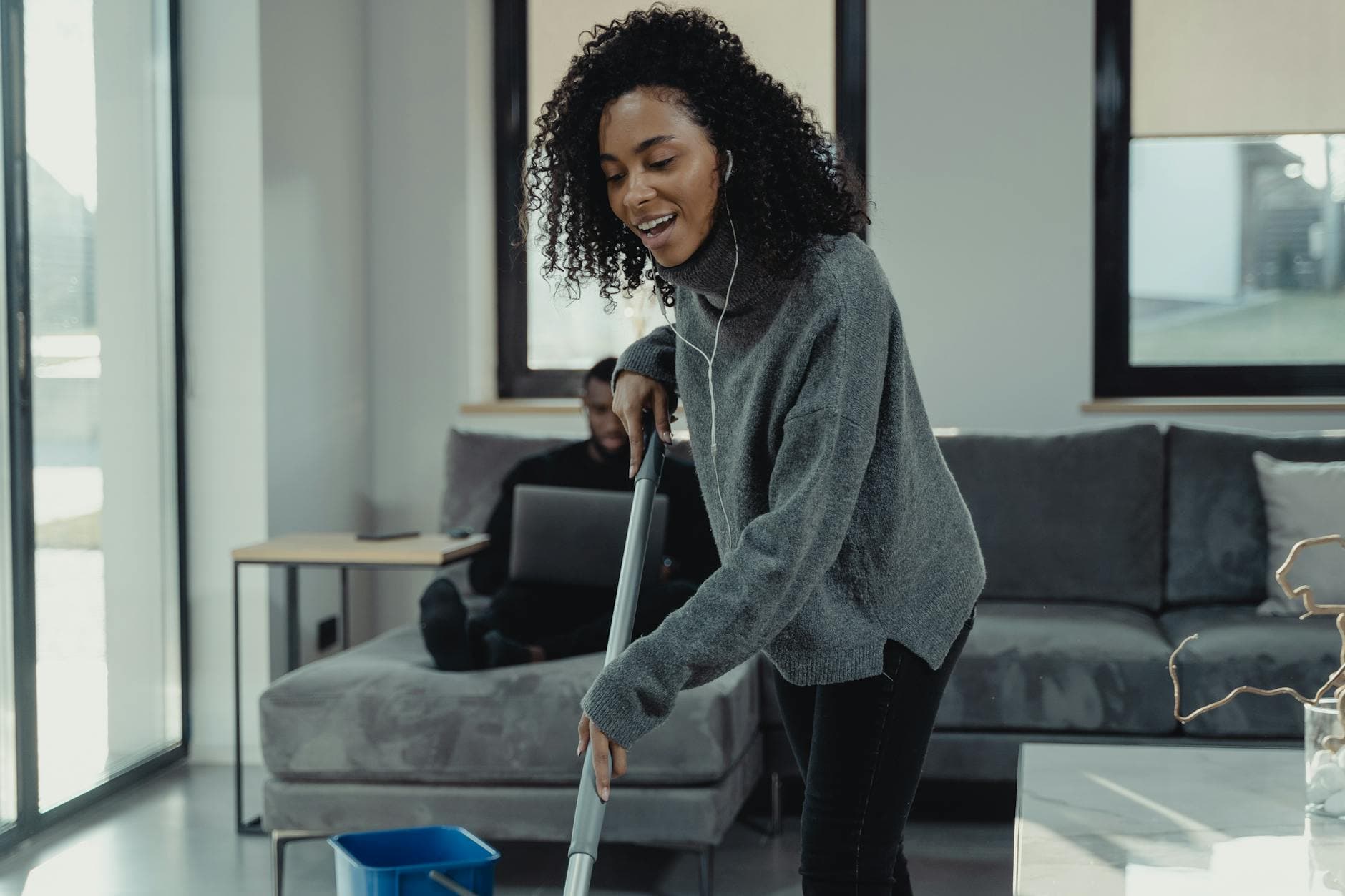 A professional house cleaner mopping the floor of a cozy New York City living room — cleaning services in DUMBO, Brooklyn