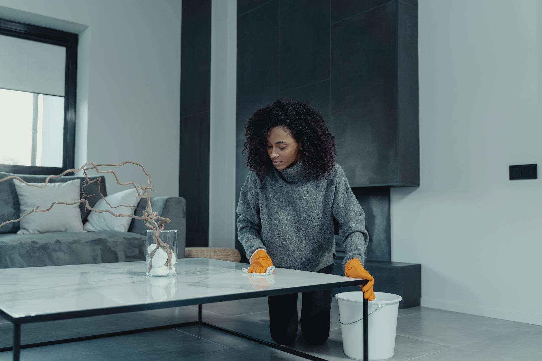 Professional house cleaner wiping a table in a contemporary New York apartment — cleaning services in Hell's Kitchen, Manhattan