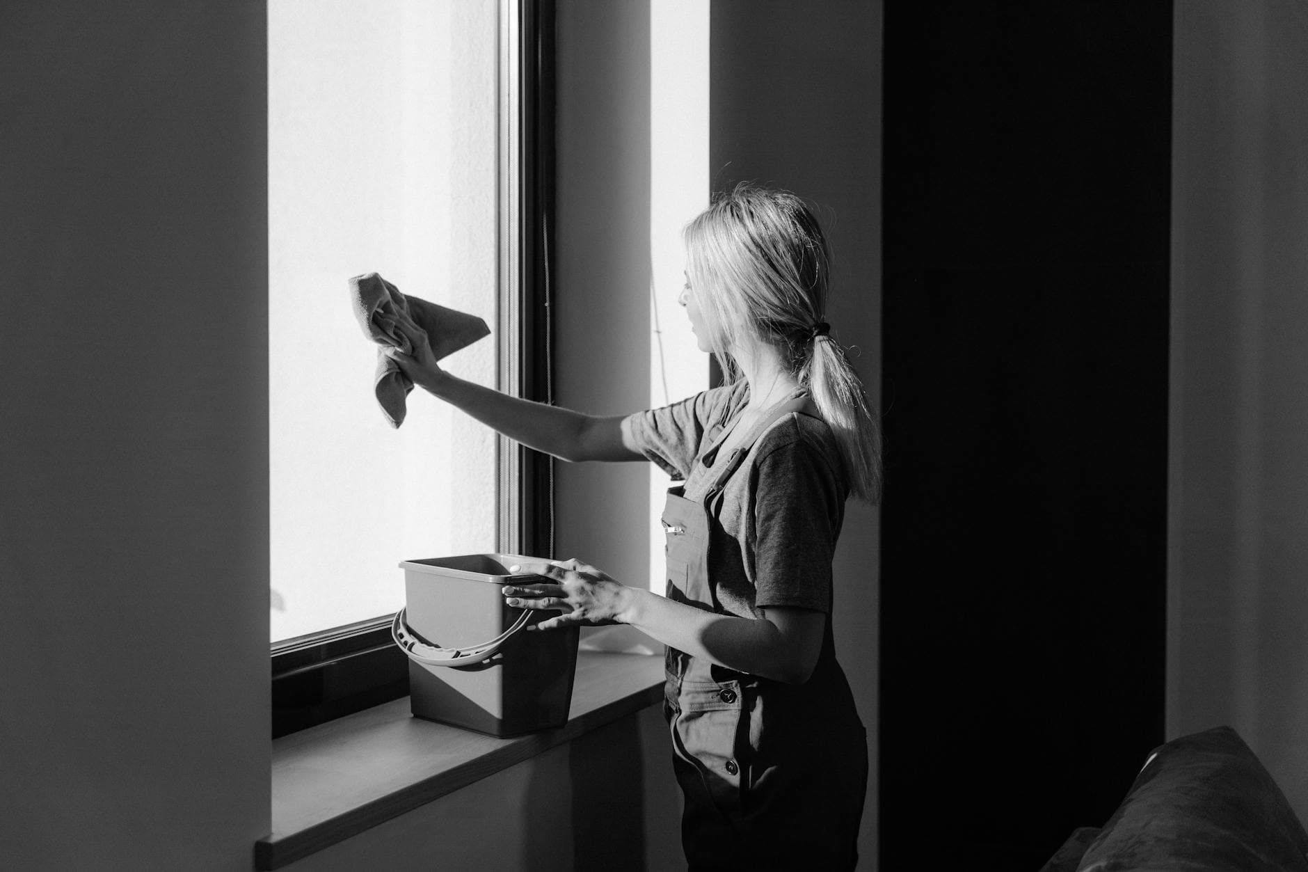 Professional window cleaning in a New York City apartment using cloth and bucket — cleaning services in New Dorp, Staten Island